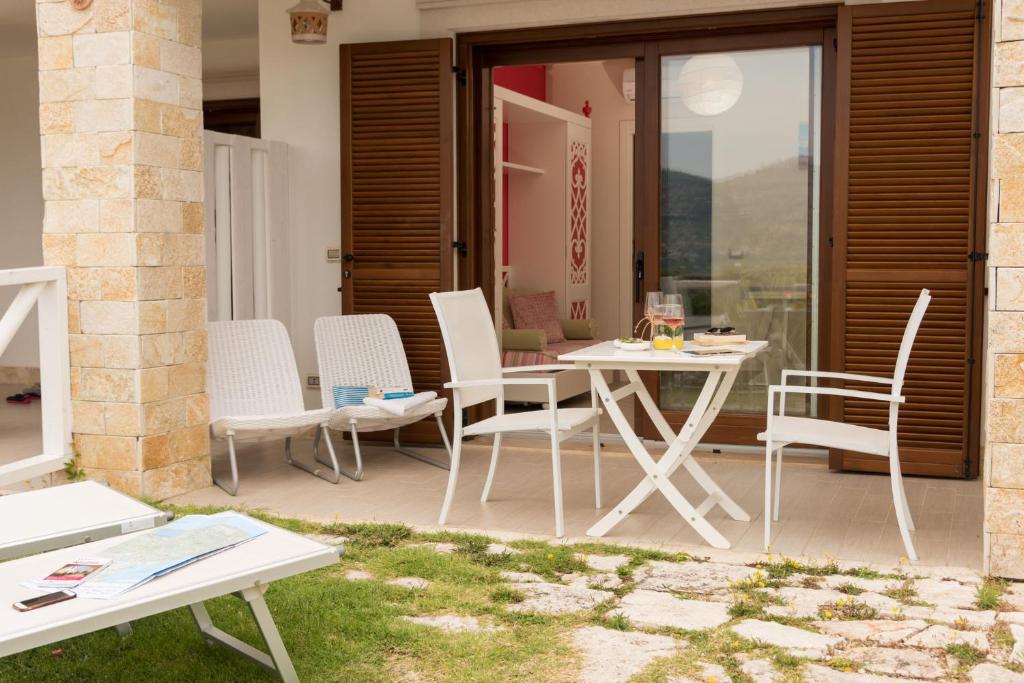 eine Terrasse mit Stühlen, einem Tisch und einem Tisch in der Unterkunft Hotel Residence Il Porto in Mattinata