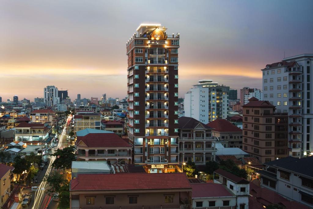 un perfil urbano con un edificio alto al atardecer en Queen Mansion, en Phnom Penh