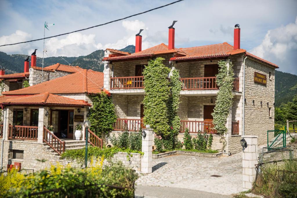Una casa con chimeneas rojas encima. en Village Inn en Áno Khóra