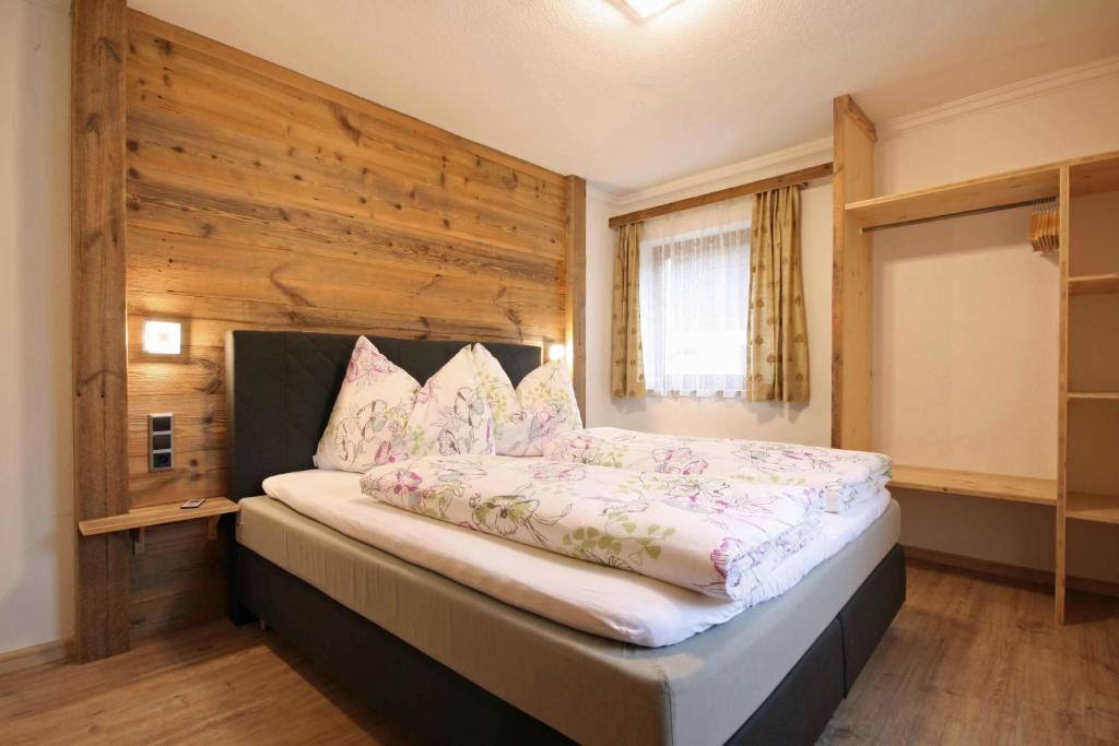 1 dormitorio con 1 cama grande y pared de madera en Almliesl ZELL-374, en Zell am See