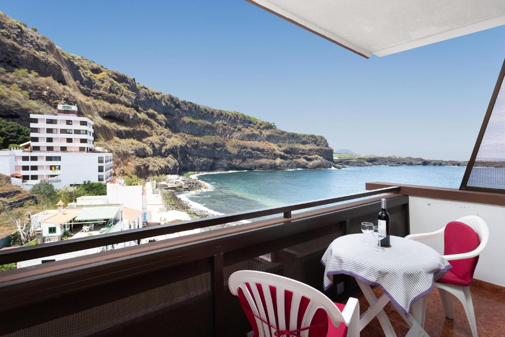 balcón con mesa, sillas y vistas al océano en Studio Atlantic View, en Icod de los Vinos