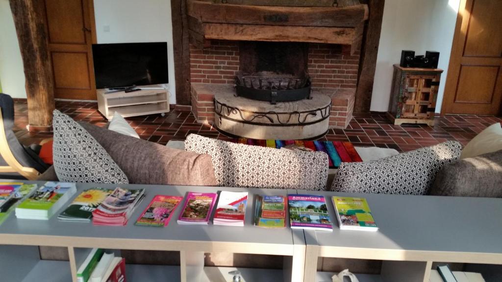einen Tisch mit Büchern darauf in einem Wohnzimmer mit Kamin in der Unterkunft Ferienwohnung Kaminzimmer in Westerstede