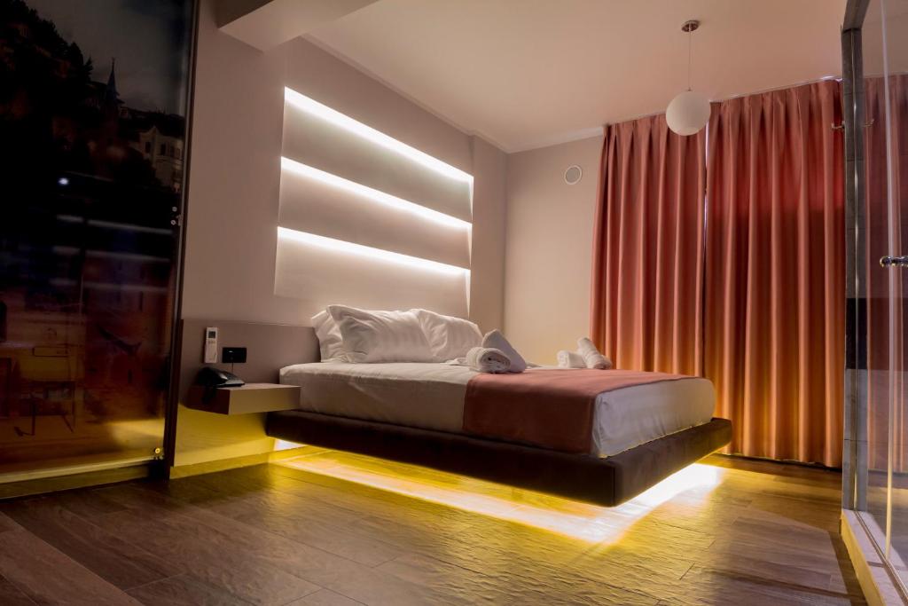 a bedroom with a bed and a large window at Hotel Pandora Residence in Tirana