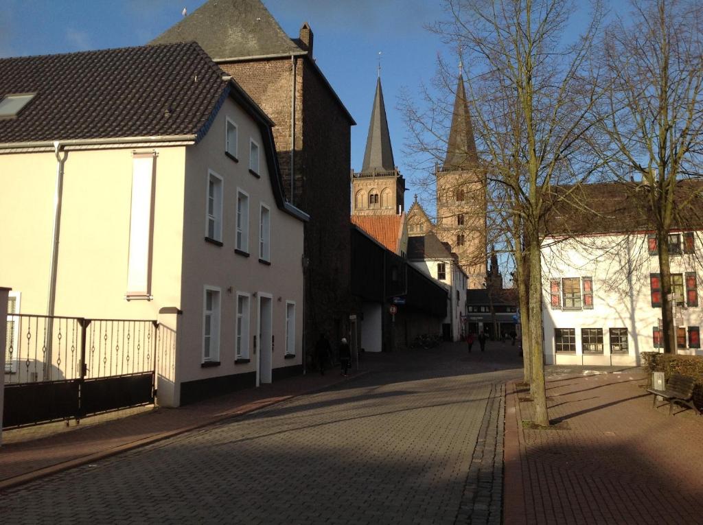una calle de la ciudad con edificios y una iglesia en Am Meerturm, en Xanten