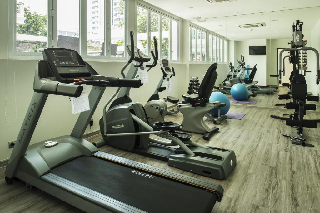 A bright, window-lined fitness room with cardio and strength equipment.