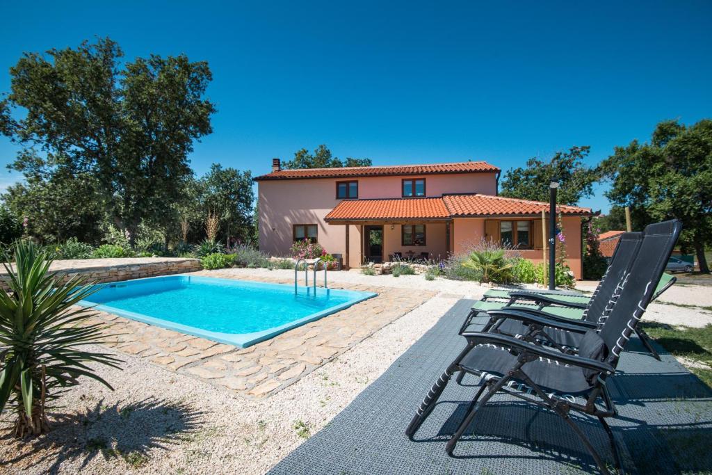 a villa with a swimming pool in front of a house at Beautiful villa Palera with private pool near Pula in Ližnjan