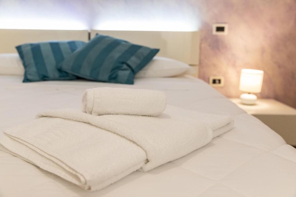 two towels are stacked on top of a bed at Hotel All'Arco in Trieste