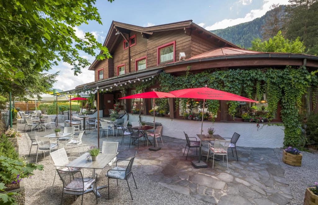 an outdoor patio with tables and chairs and a building at Gasthof Restaurant Waldcafé in Mayrhofen