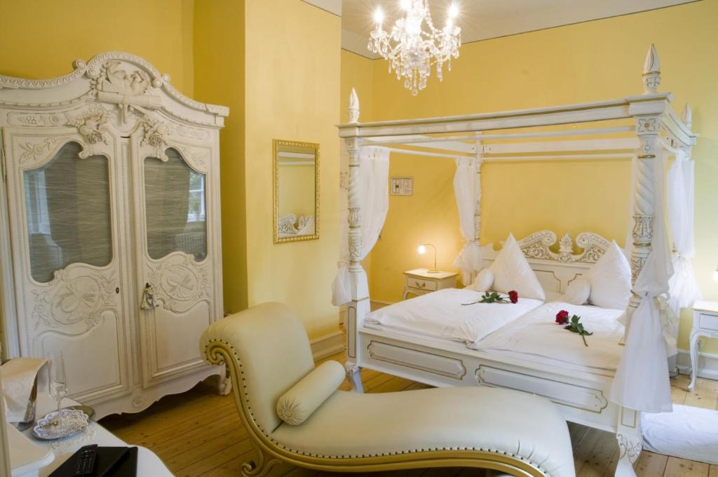 ein Schlafzimmer mit einem weißen Bett und einem Stuhl in der Unterkunft SchlossHOTELGedern in Gedern