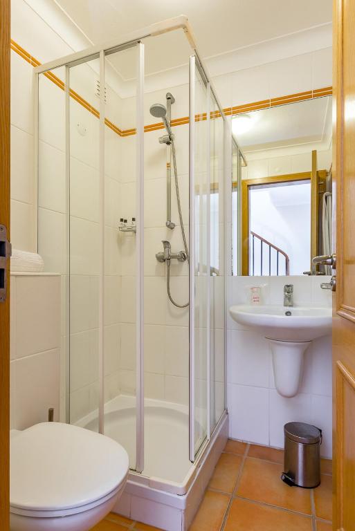 a bathroom with a shower and a toilet and a sink at Pestana Palm Gardens in Carvoeiro