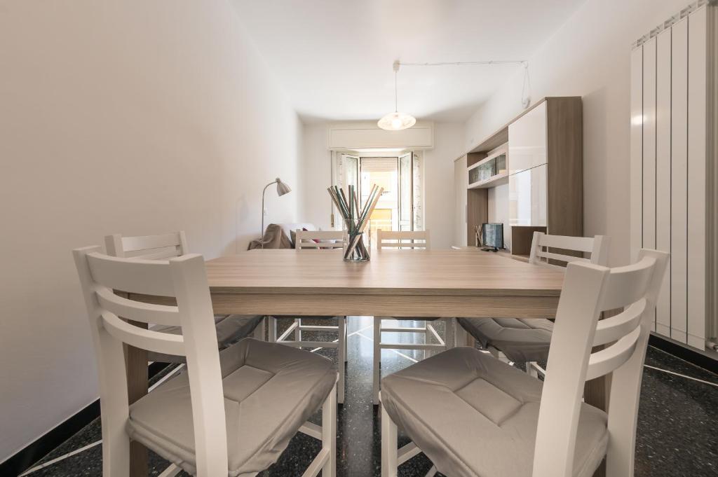 una cucina e una sala da pranzo con tavolo e sedie in legno di Casa di Marita a Finale Ligure