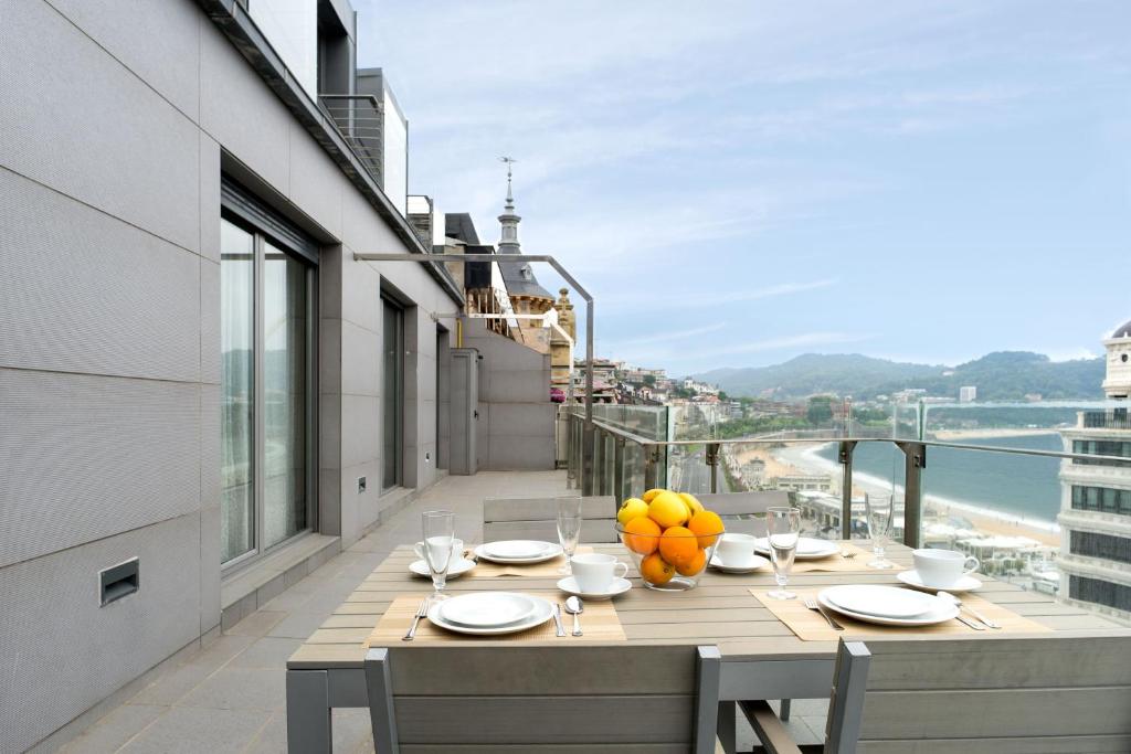 a table on a balcony with a view of the ocean at Niza La Concha - IB. Apartments in San Sebastián