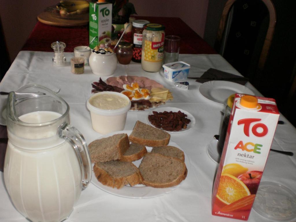 een tafel met een bord brood en een kan melk bij Rooms Lutra in Bilje