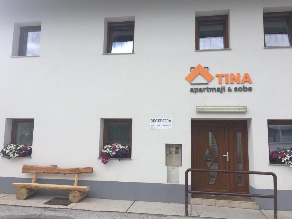 a building with a door and a bench in front of it at Apartmaji in sobe Tina in Kranjska Gora
