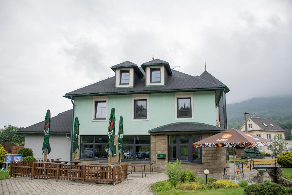 a large building with tables and chairs in front of it at Penzion Šafrán in Jeseník