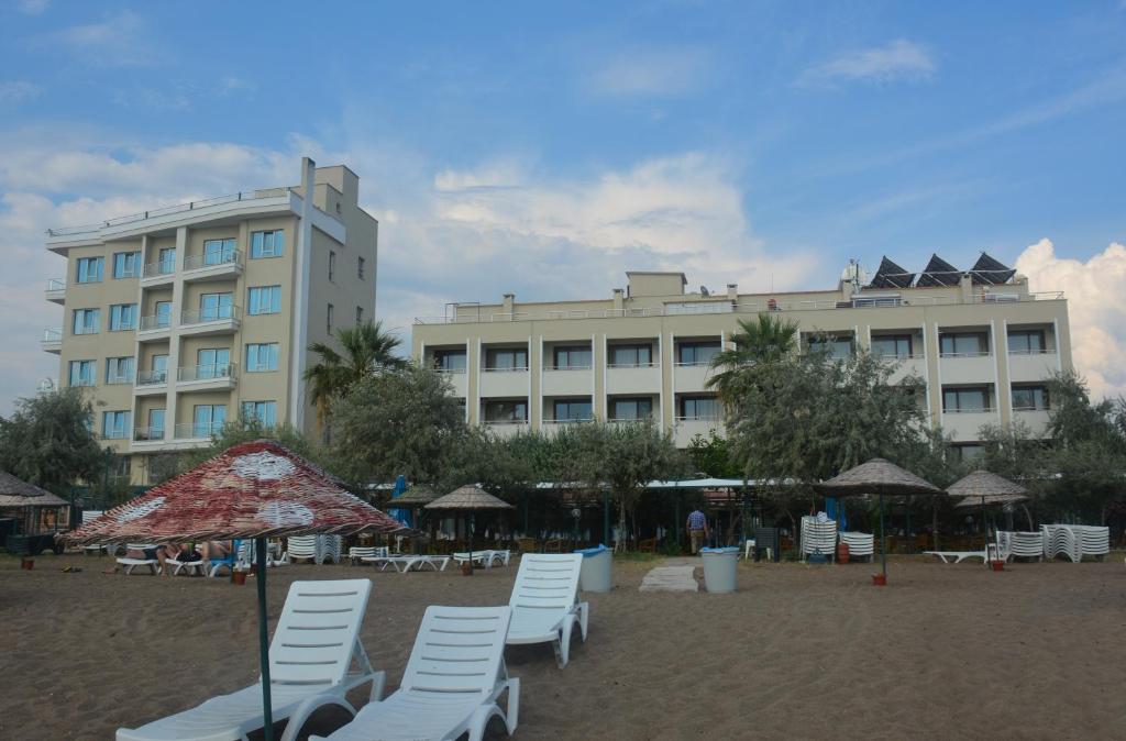 ディキリにあるDikelya Hotelの建物のある海岸の椅子・傘