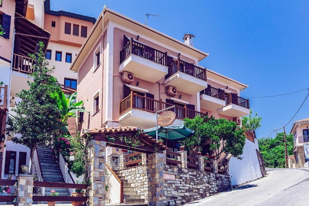 a tall building with balconies on a street at Golden Sun in Agios Ioannis Pelio