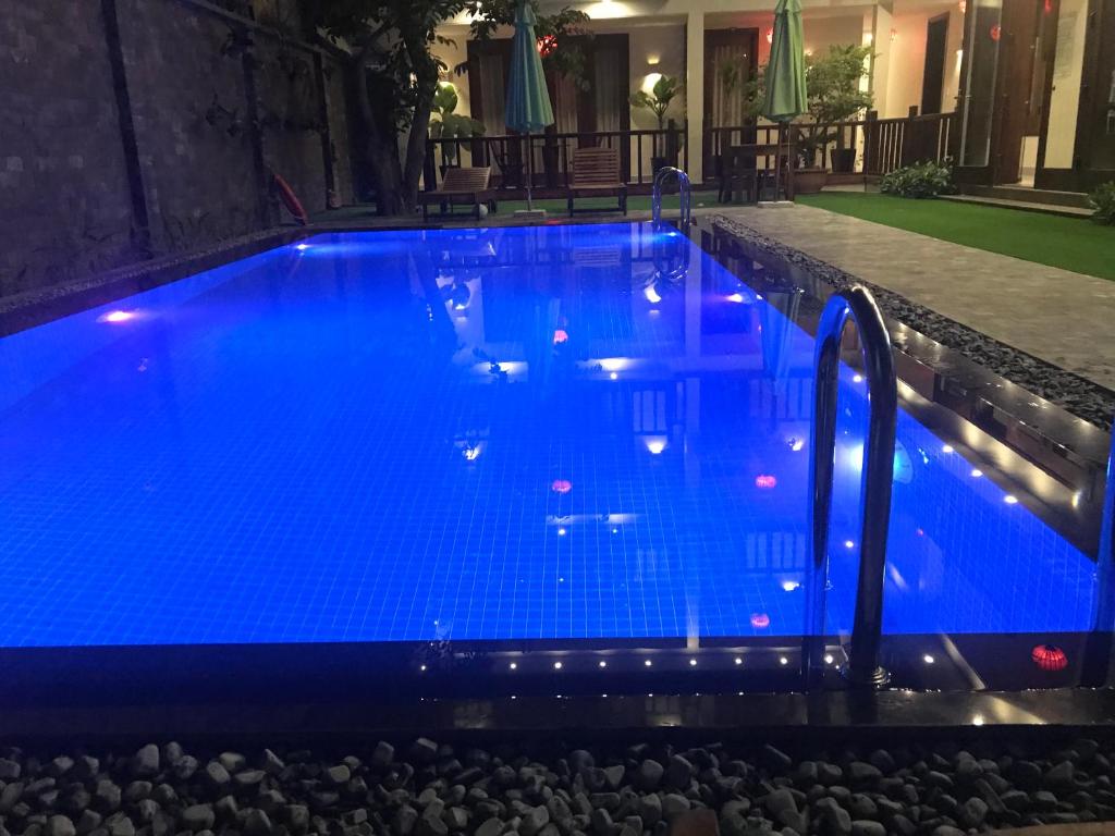 a large blue pool with rocks around it at Village Moon Villa in Hoi An