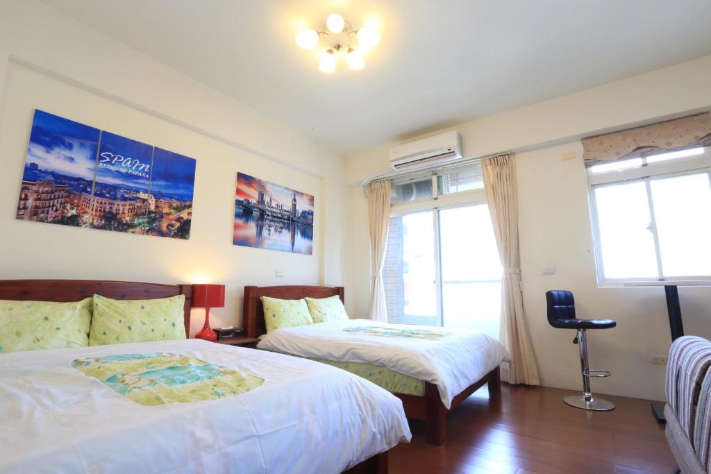 a hotel room with two beds and a window at Downshifters House in Tongluo