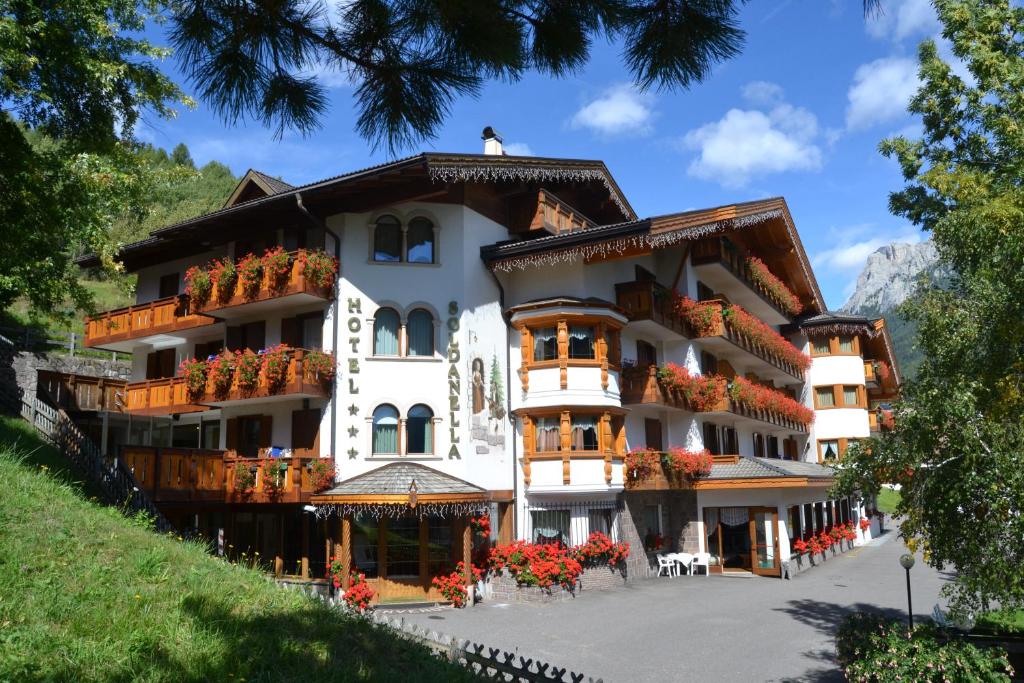 un grande edificio bianco con dei fiori di fronte di Hotel La Soldanella a Moena