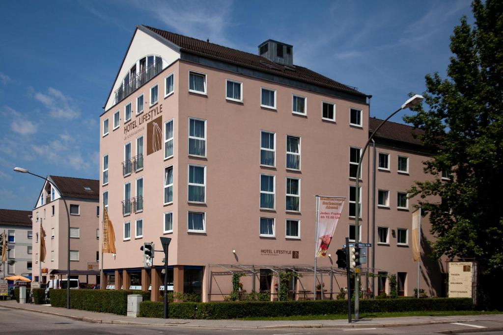 duży budynek na ulicy z światłem ulicznym w obiekcie Hotel Lifestyle w mieście Landshut