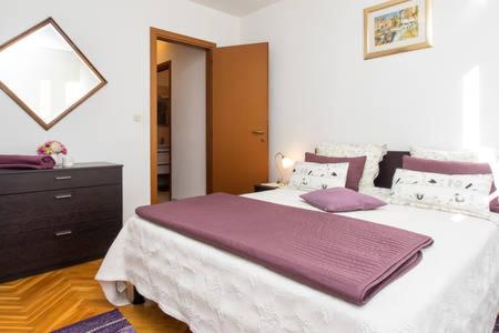 a bedroom with a large bed and a dresser at Apartment Bucka in Split