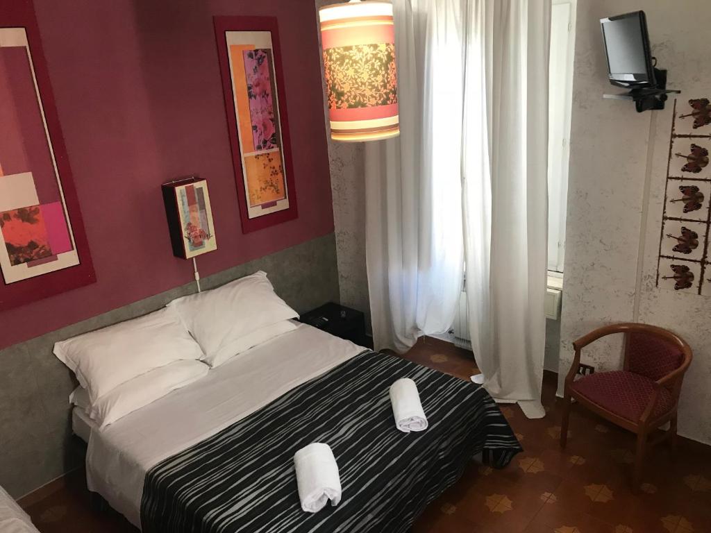 a bedroom with a bed with two white towels on it at Roma Room Hotel in Rome