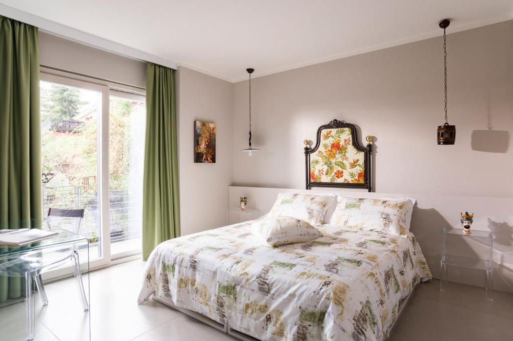 a white bedroom with a bed and a window at B&B Etna Dream in Zafferana Etnea