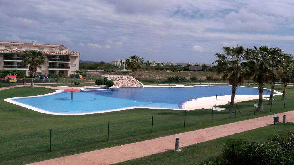 une grande piscine dans un champ planté de palmiers dans l'établissement Excepcional Chalet adosado de lujo "Una Escapada al Paraíso", à Sant Jordi