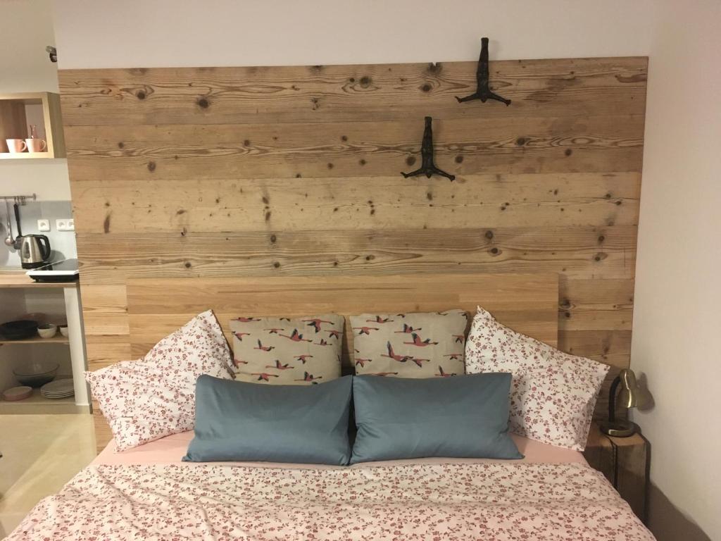um quarto com uma cabeceira em madeira e uma cama com almofadas em Pension Andante em Spindleruv Mlyn