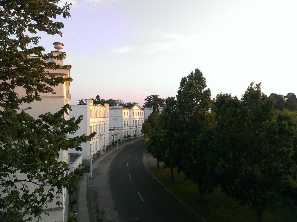 Blick auf eine Straße mit Bäumen und Gebäuden in der Unterkunft Fürstlich wohnen in Putbus