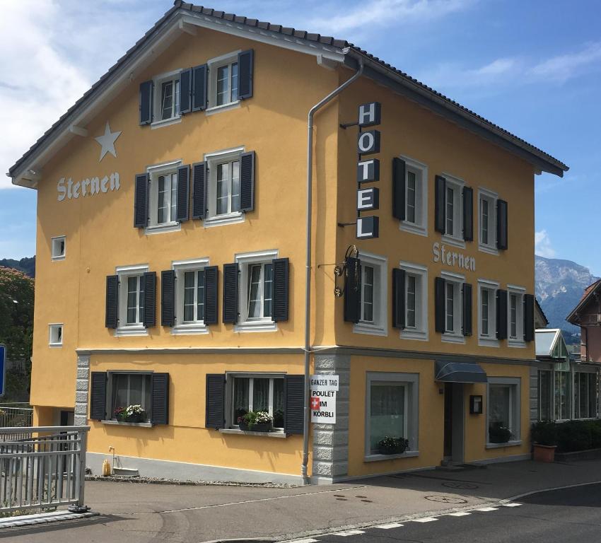 a yellow building with a sign on the side of it at Hotel Sternen in Sisikon