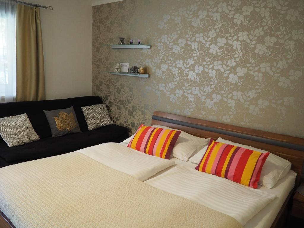 Un dormitorio con una cama con almohadas de colores. en Penzion Pohoda, en Lednice
