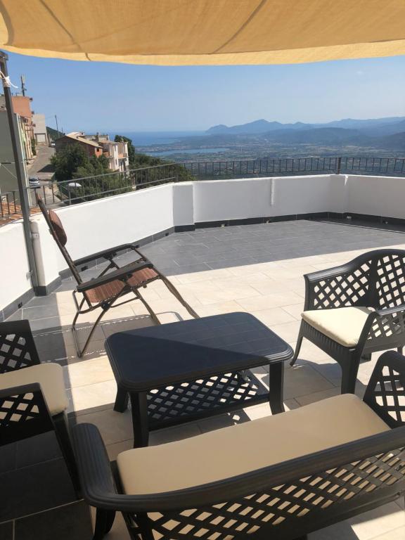 d'une terrasse sur le toit avec des chaises et des tables. dans l'établissement Serraenna Bedrooms, à Baunei