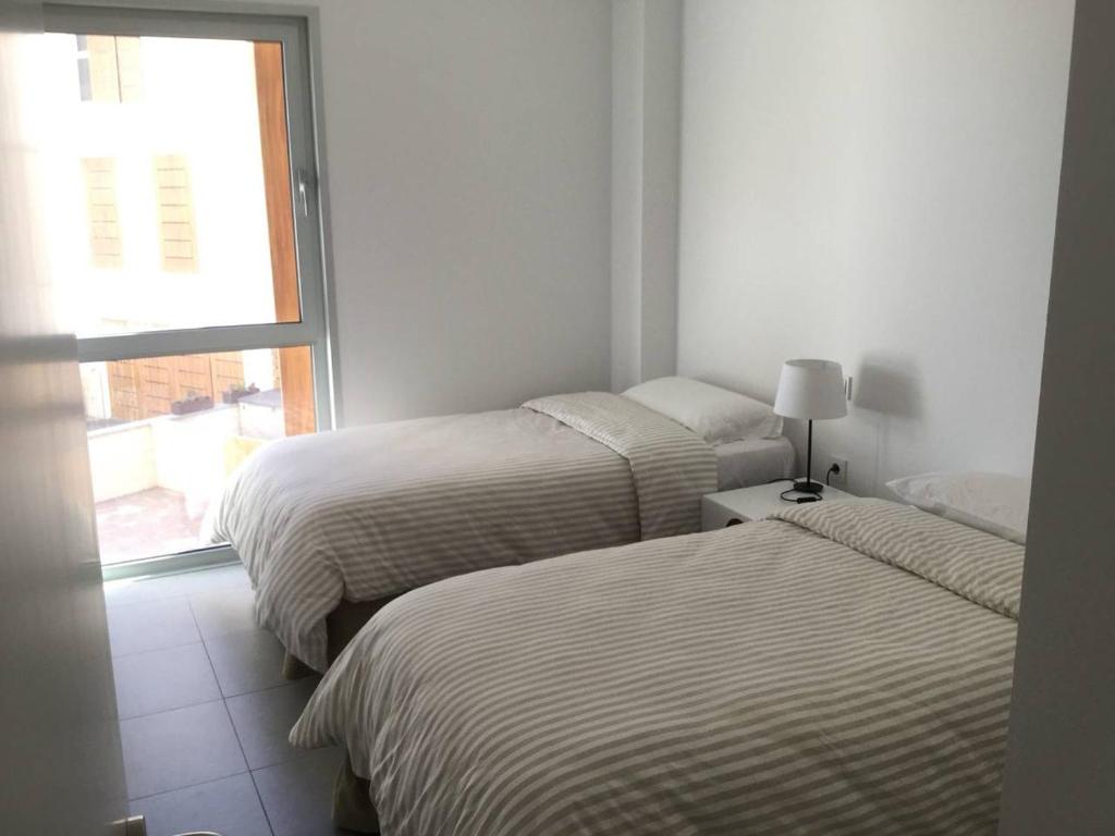 A bed or beds in a room at AMAZING DUPLEX on the beach