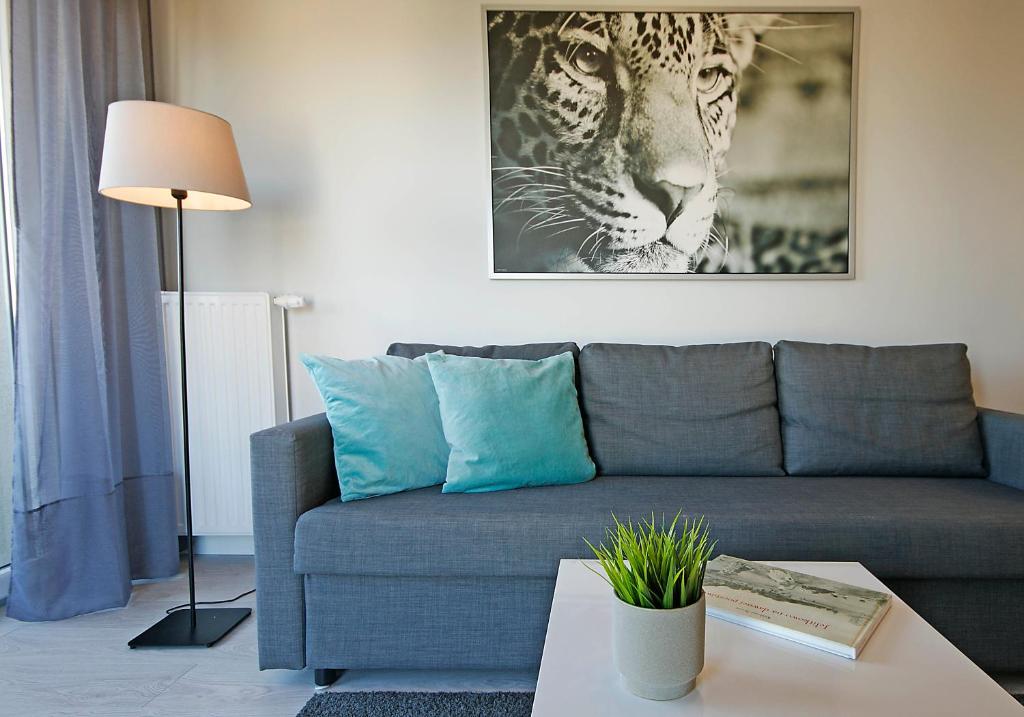 a living room with a couch and a picture of a tiger at IRS ROYAL APARTMENTS Apartamenty IRS Albatros in Gdańsk
