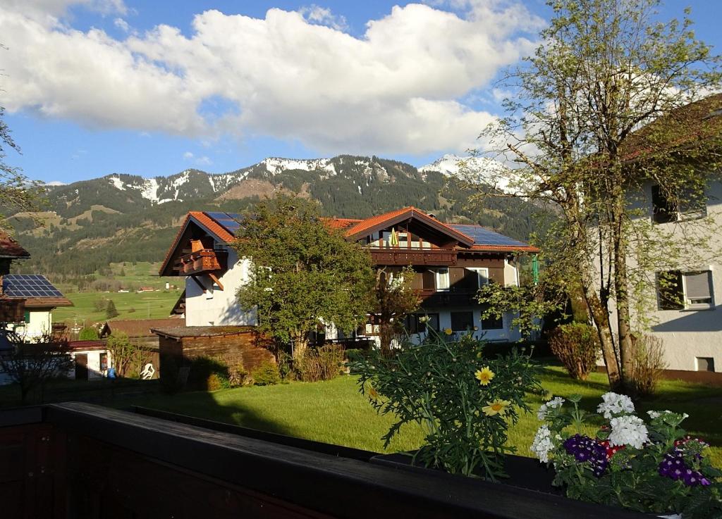 a view of a house with mountains in the background at Allgäu-Ferienwohnung Jung in Fischen