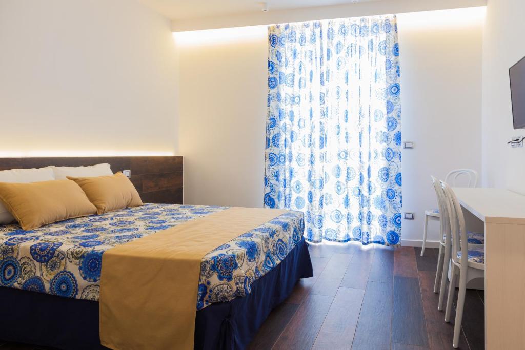 a bedroom with a bed and a blue and white curtain at Casa Restino in Torre del Greco