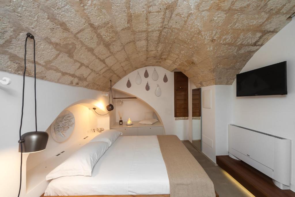 a bedroom with a large bed with a stone ceiling at Palazzo Fiscaiolo in Monopoli