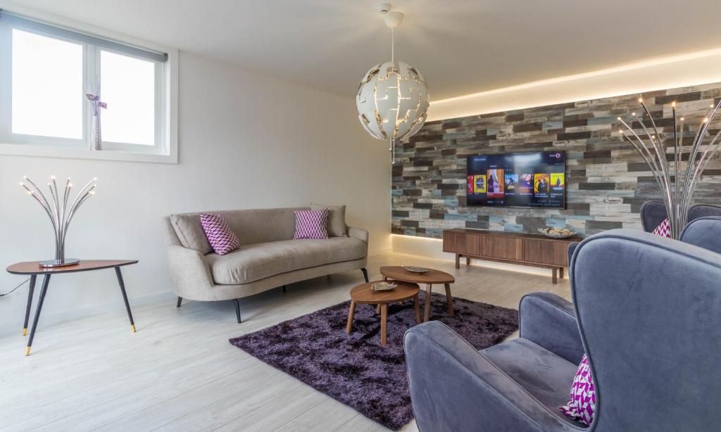 uma sala de estar com dois sofás e uma televisão em House General Torres em Vila Nova de Gaia