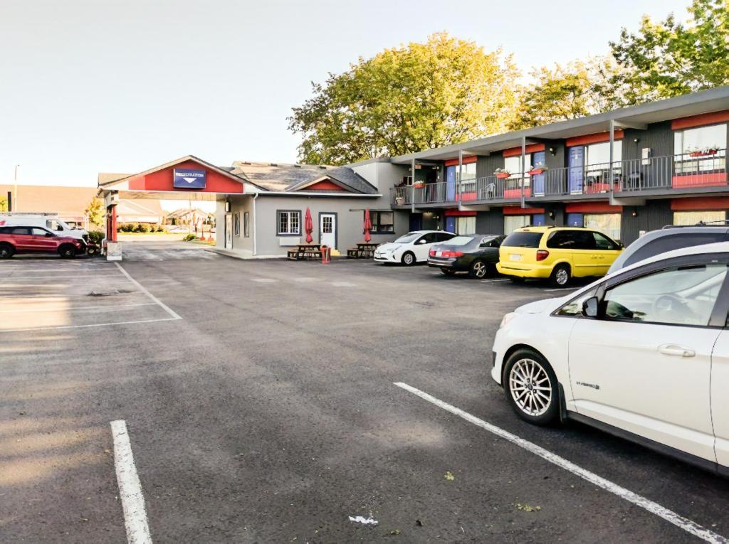 un estacionamiento con autos estacionados frente a un motel en Villager Lodge Niagara Falls, en Niagara Falls