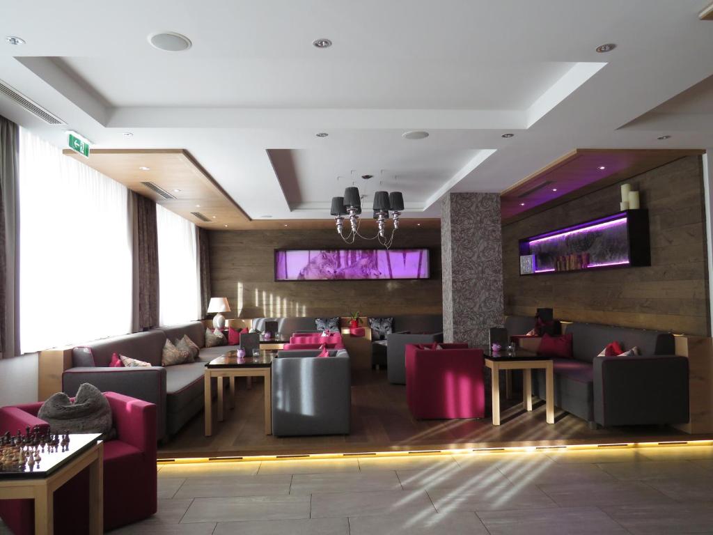 restauracja z kanapami, stołami i telewizorami w obiekcie Wolfs Aparts + More w mieście Ischgl