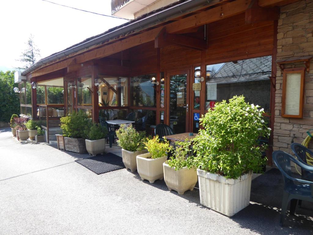 a row of potted plants outside of a restaurant at Hotel Les Chenets in Saint-Julien-en-Champsaur