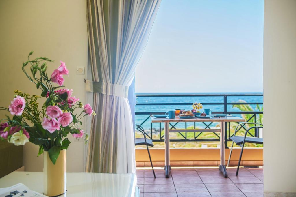 a room with a table and a view of the ocean at Nanakis Beach Apartments in Stavros