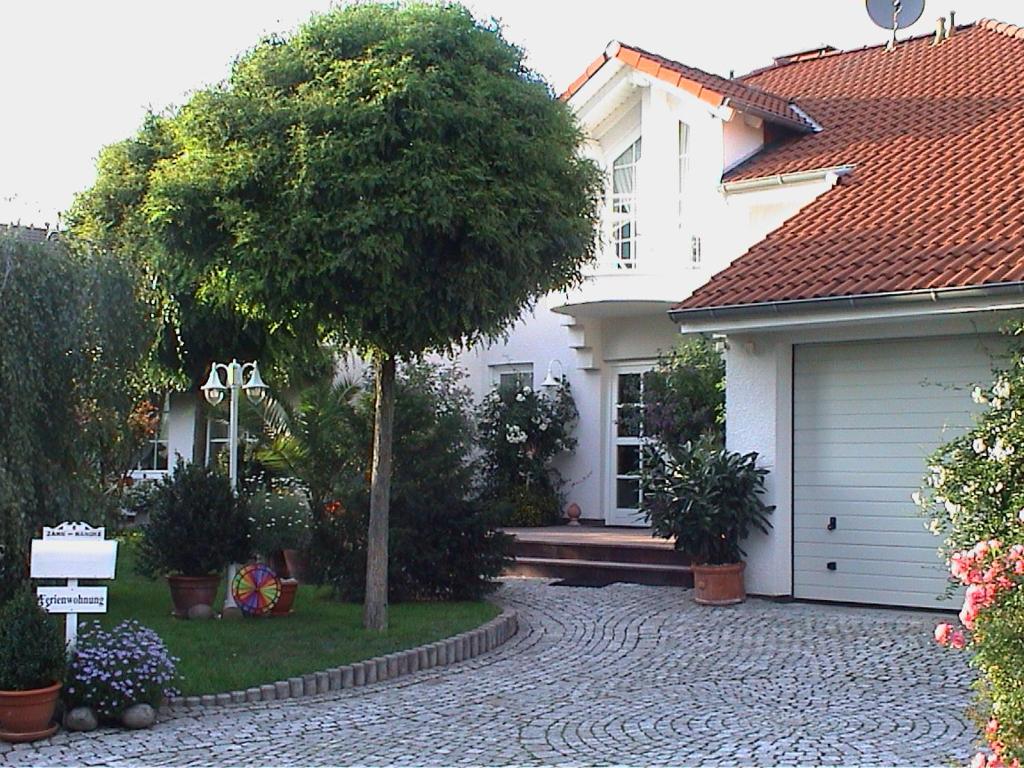 una casa blanca con un árbol y una entrada en Fewo "Habichtswald", en Niedenstein