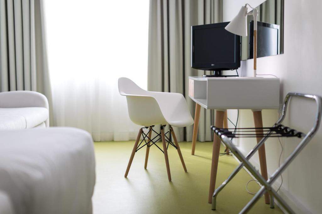 a room with two chairs and a tv on a table at Legendary Porto Hotel in Porto