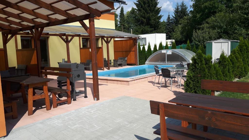 eine Terrasse mit Bänken und einem Pool in der Unterkunft Apartmány Sophia 5 a 6 in Velké Losiny