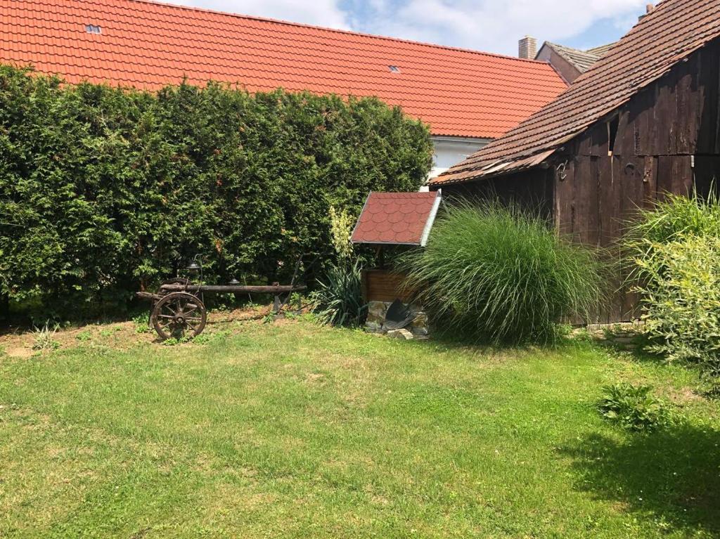 einen Garten mit einer Scheune und einem alten Rad im Hof in der Unterkunft Chalupa 73 in Desov