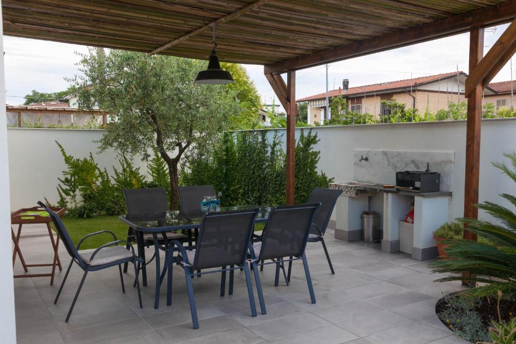 patio ze stołem, krzesłami i sprzętem do grillowania w obiekcie Macchia home w mieście Marina di Carrara