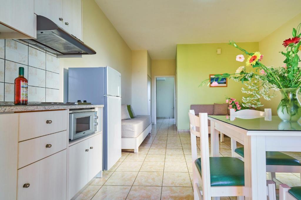 a kitchen and dining room with a table and a couch at Nanakis Beach Apartments in Stavros